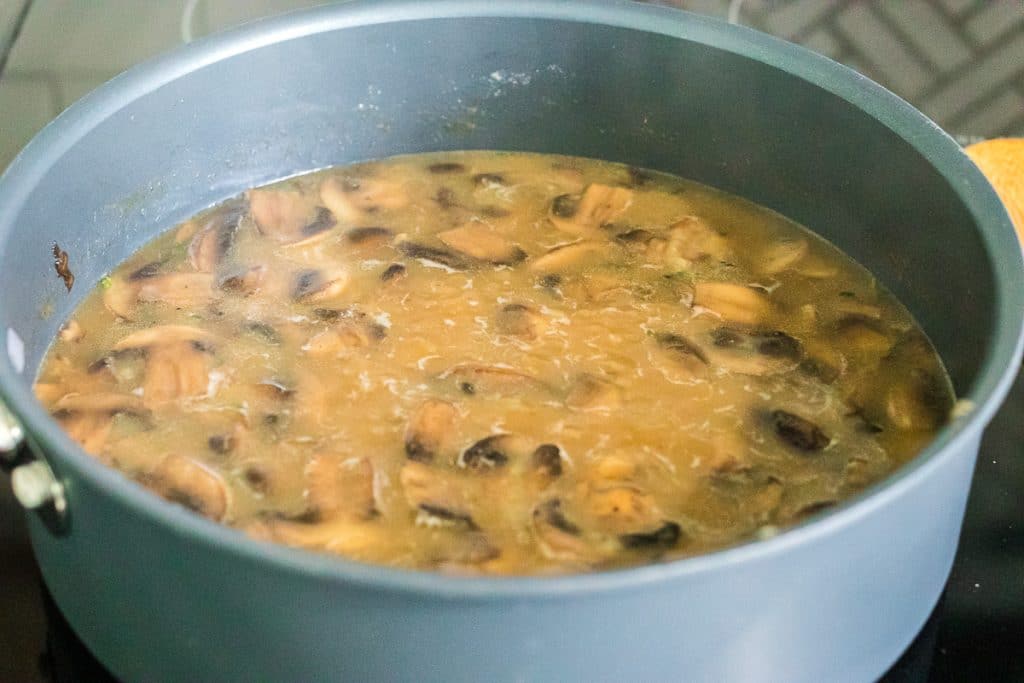 mushroom gravy simmering in a skillet.