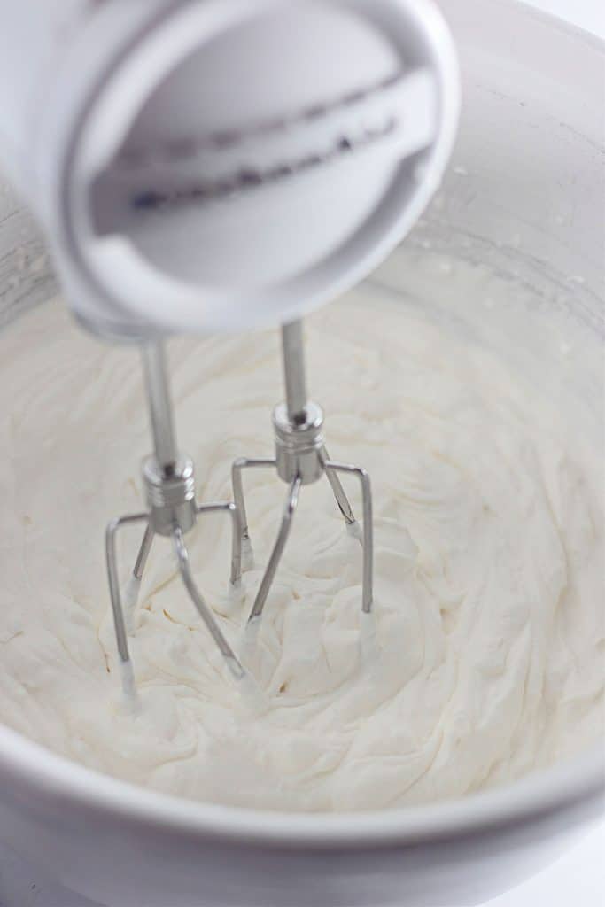 hand mixer in a bowl of homemade cool whip.