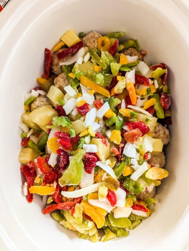 overhead shot of peppers and onions in a slow cooker.