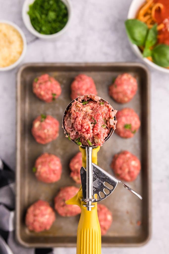 cookie scoop portioning out meatball mixture.