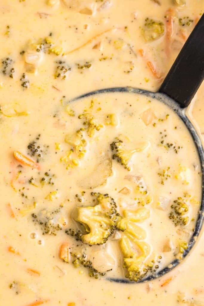 overhead shot of a ladle in broccoli cheddar soup.
