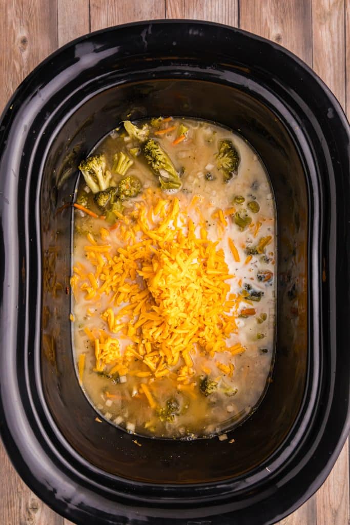 overhead shot of shredded cheddar in a black crockpot.