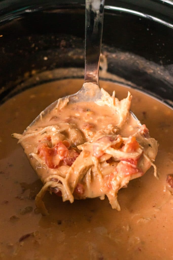 ladle scooping buffalo chicken chili from a crockpot.