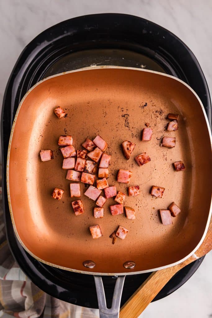 diced ham fried in a skillet.