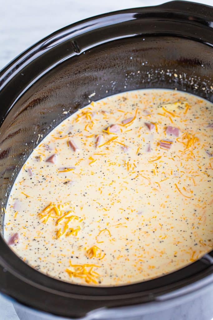 overhead shot of milk and cheese in a black crockpot.