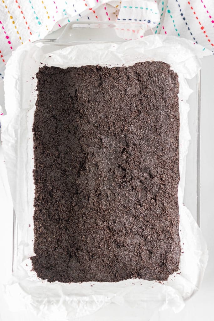 oreo cookie crushed pressed into a baking dish.