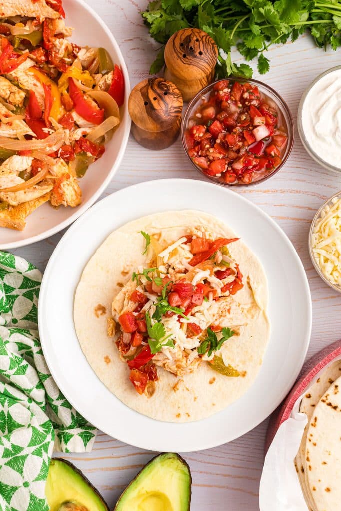 overhead shot of chicken fajita on a tortilla.