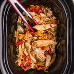 tongs in a slow cooker with chicken fajitas.