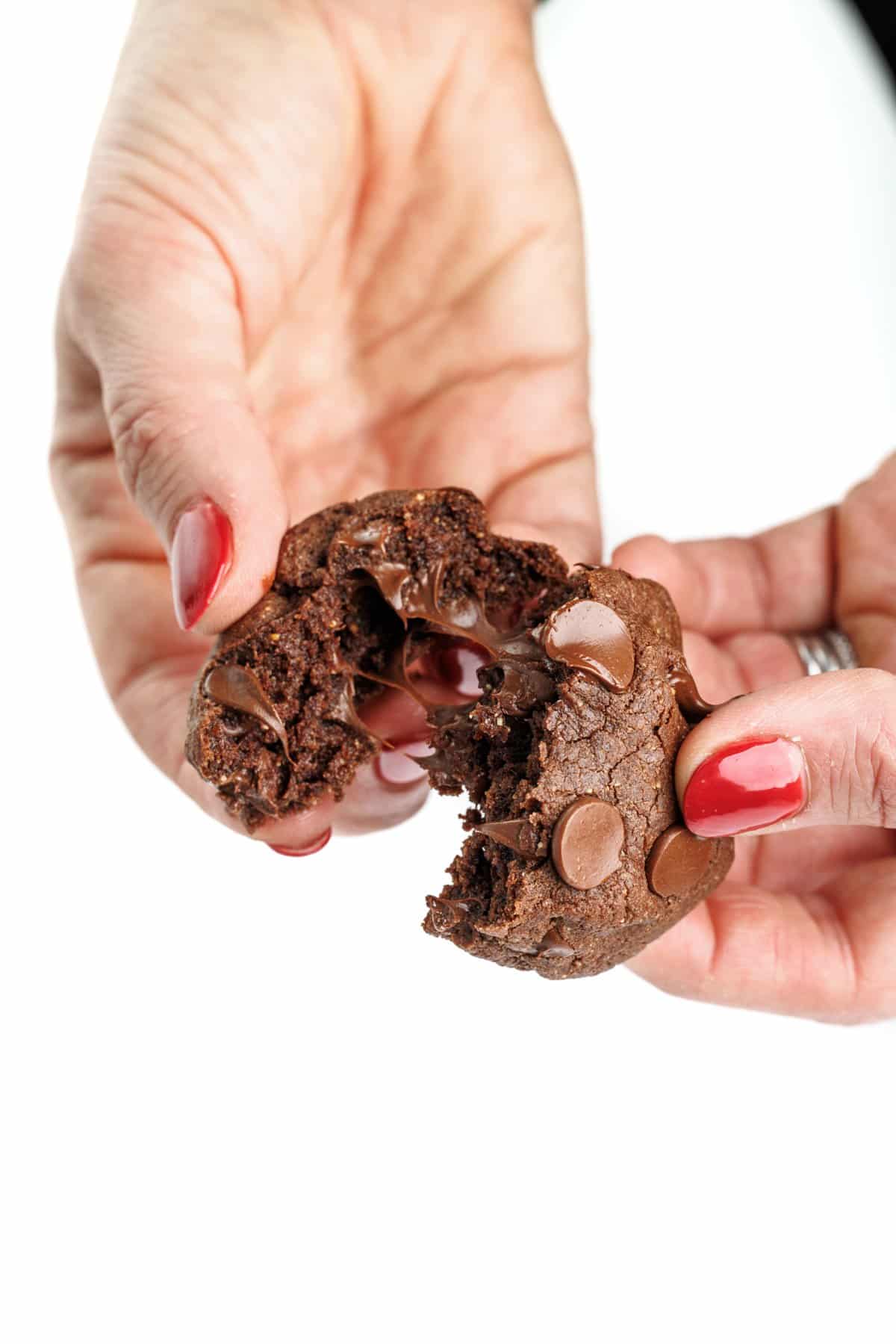 Breaking apart a buckwheat double dark chocolate brownie cookie.
