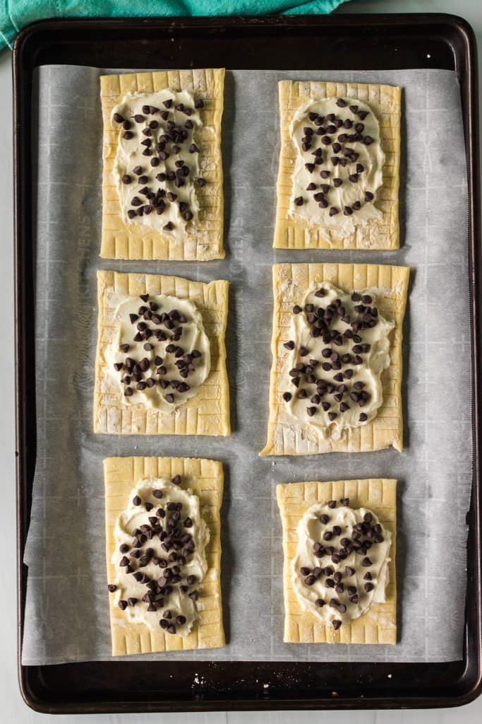 overhead shot of mini chocolate chips sprinkled on puff pastries.