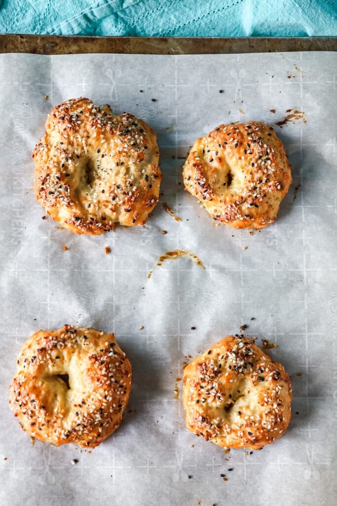 overhead shot of bagels on a baking sheet.