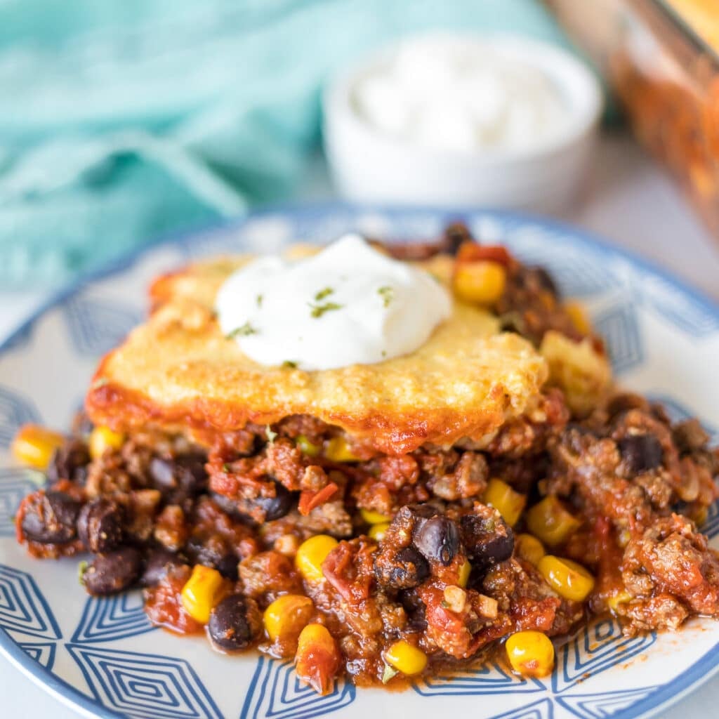 plate of chili cornbread casserole topped with sour cream.