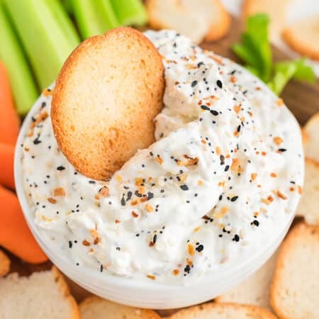 bagel chip dipping into everything bagel dip.