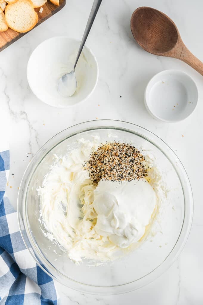 overhead shot of mixing bowl with cream cheese, sour cream, and everything bagel seasoning.