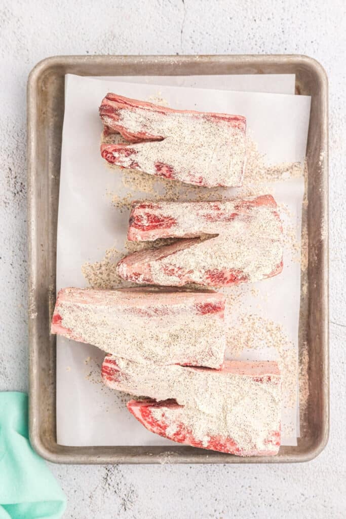 seasoning sprinkled onto short ribs.