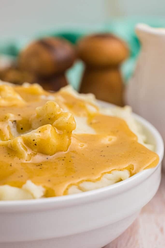 closeup of bowl of mashed potatoes with gravy.