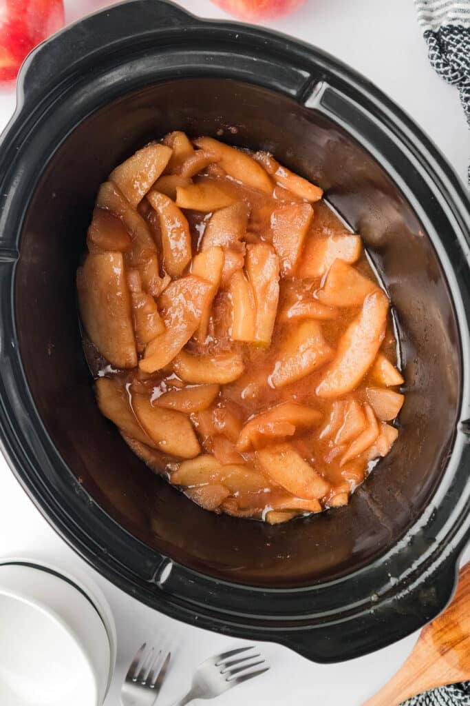 overhead shot of fried apples in a black crockpot.