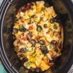 overhead shot of chicken enchilada casserole in a slow cooker.