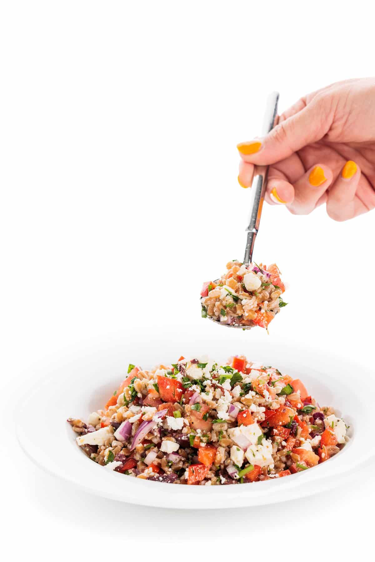 Spoonful of farro greek salad with feta and dill.