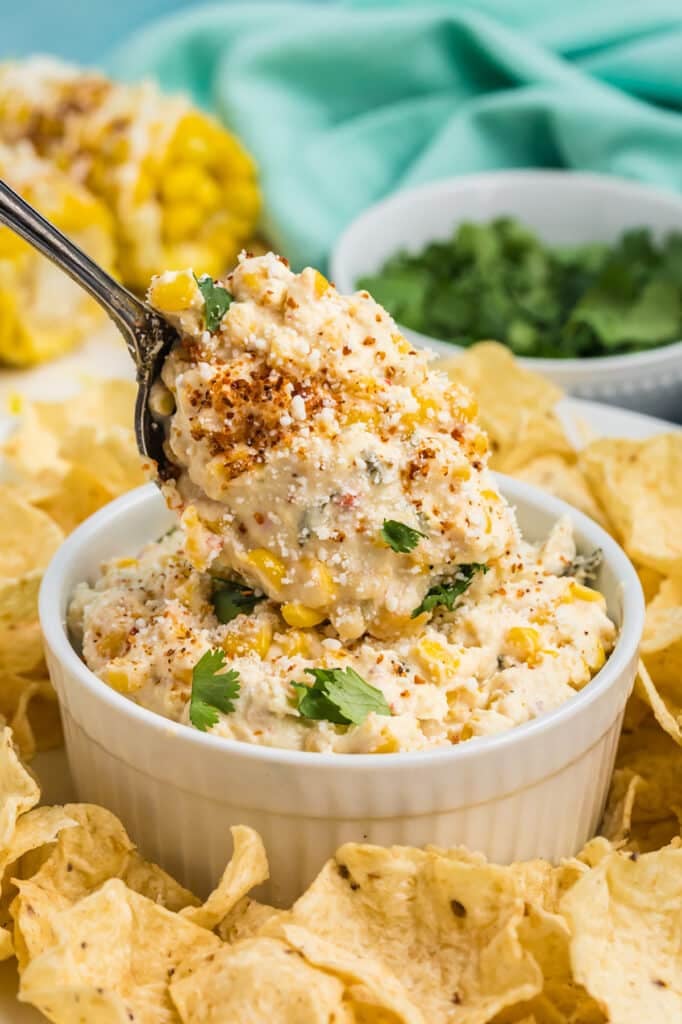 spoon scooping smoked corn dip into a bowl.
