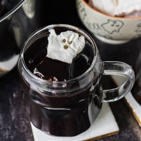 mug of black hot cocoa with a ghost marshmallow.