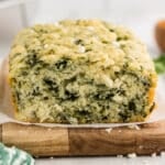 loaf of spinach feta bread on a wood board.