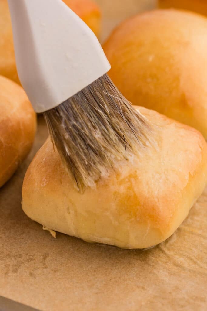 pastry brush brushing butter on a roll.