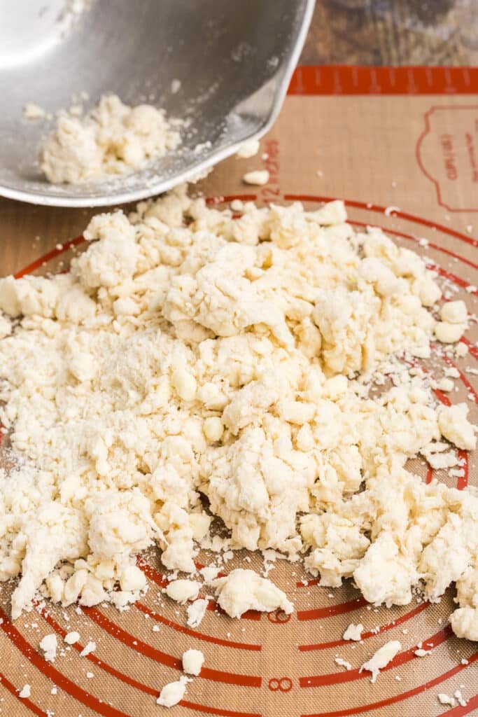 crumbly pie crust on a silicone mat.