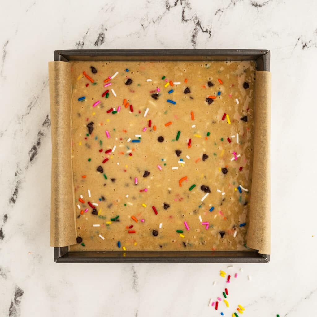 overhead shot of confetti snack cake batter in a square pan.