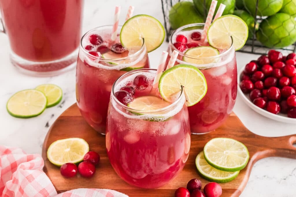 three glasses of cranberry pineapple punch on a serving tray.