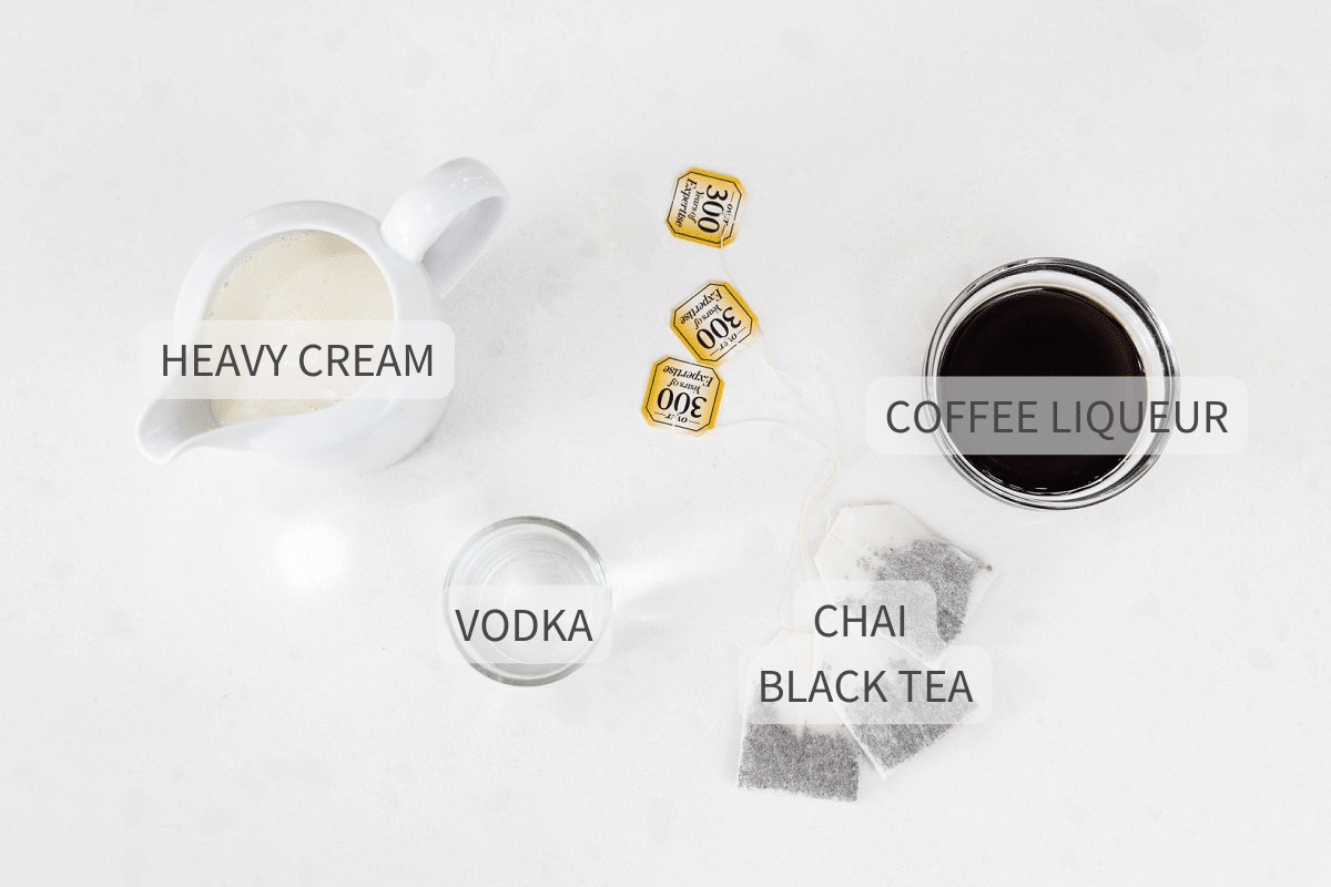 Ingredients for a chai infused white Russian against a white backdrop, with labels for each.