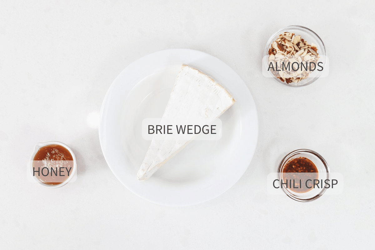 Labeled ingredients for hot honey baked brie against a white backdrop.