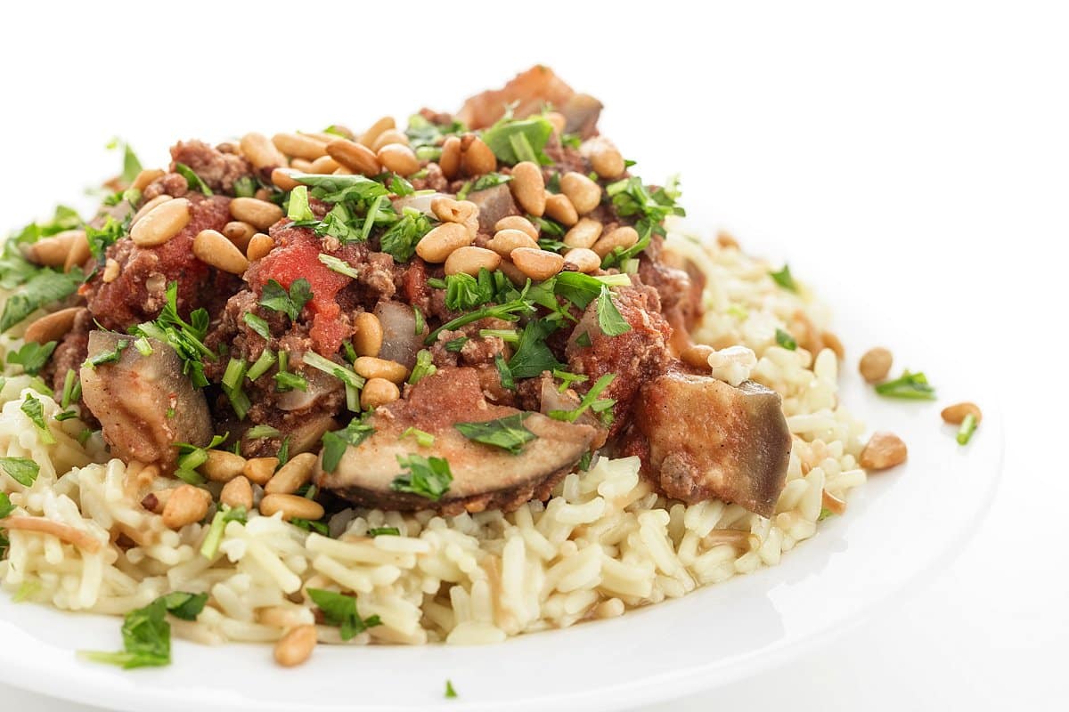 5-ingredient slow cooker beef and eggplant garnished with pine nuts and parsley.