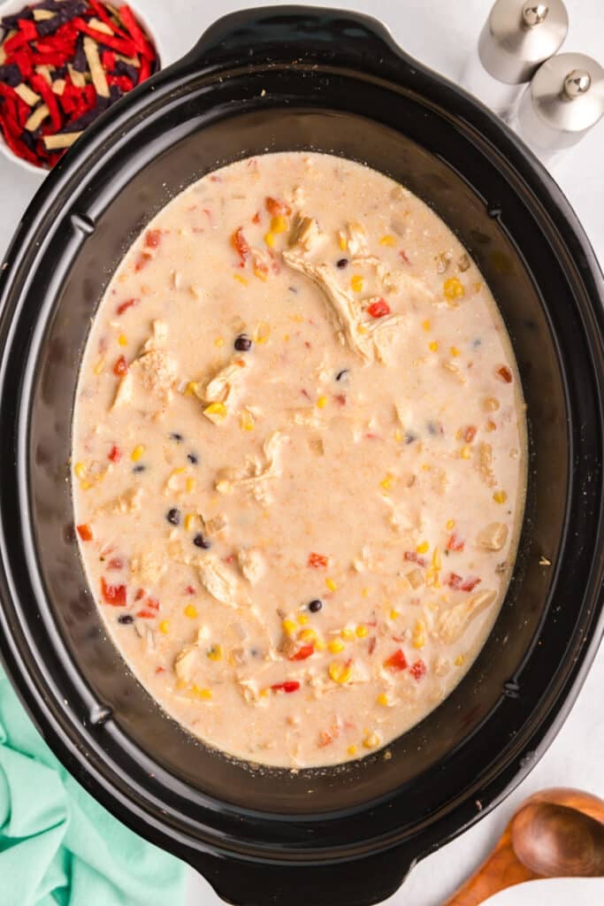 creamy tortilla soup in a black crockpot.