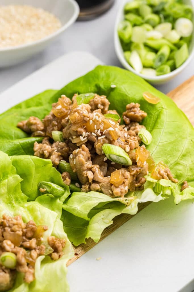 Lettuce wraps filled with chicken mixture and sesame seeds.
