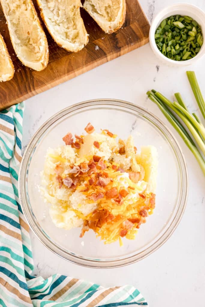 baked potato, bacon, and cheese in a mixing bowl.