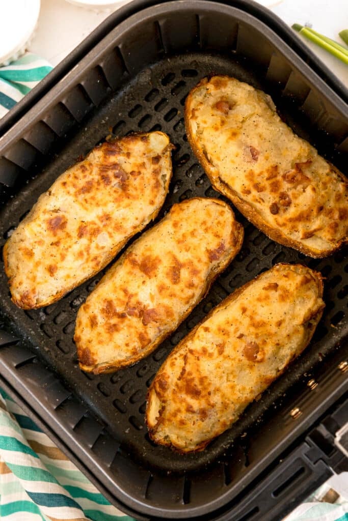 twice baked potatoes in an air fryer basket.