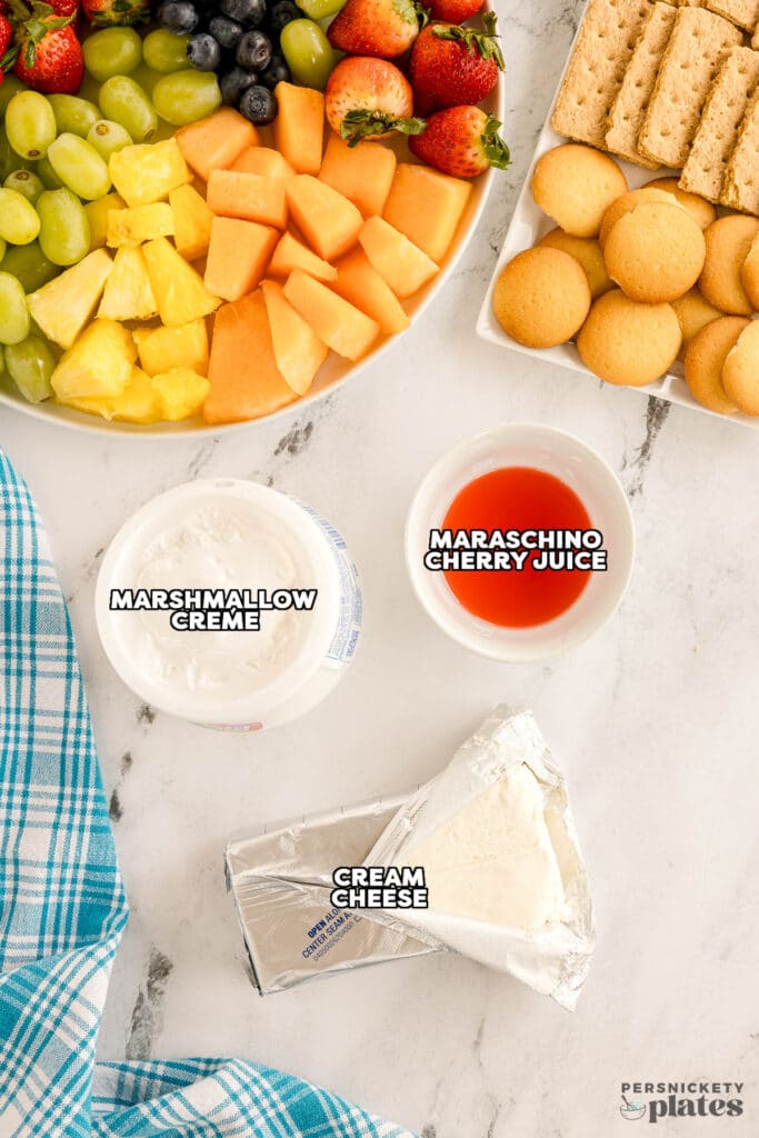 Ingredients for cream cheese fruit dip displayed on a marble countertop.