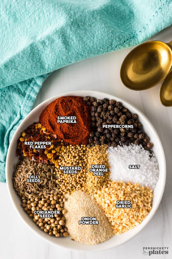 A bowl with neatly arranged spices labeled for Montreal steak seasoning.