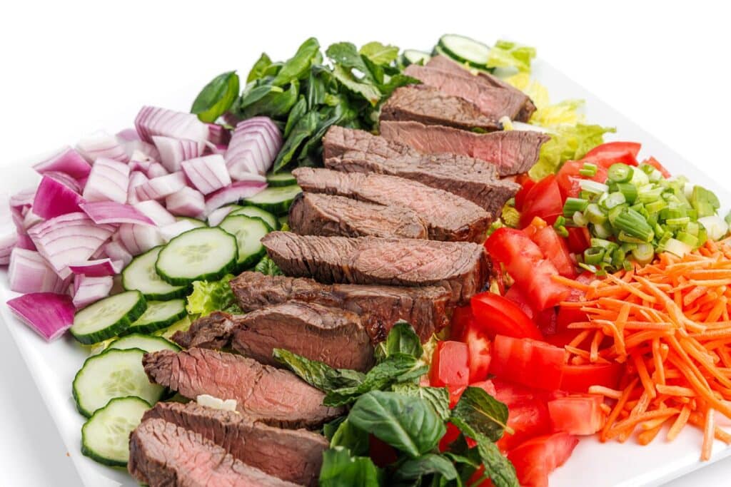 One of 20 high-protein salad recipes, Vietnamese beef salad arranged on a large platter.