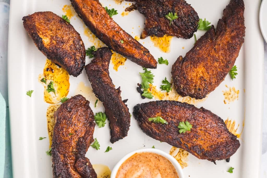 overhead shot of blackened tenders on a platter with dipping sauce.