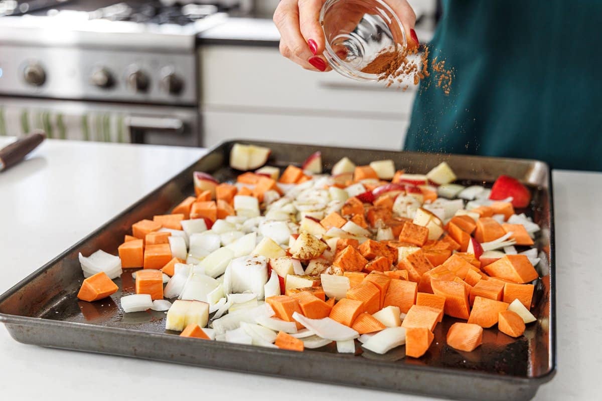 Sprinkling cinnamon over the top of diced vegetables.