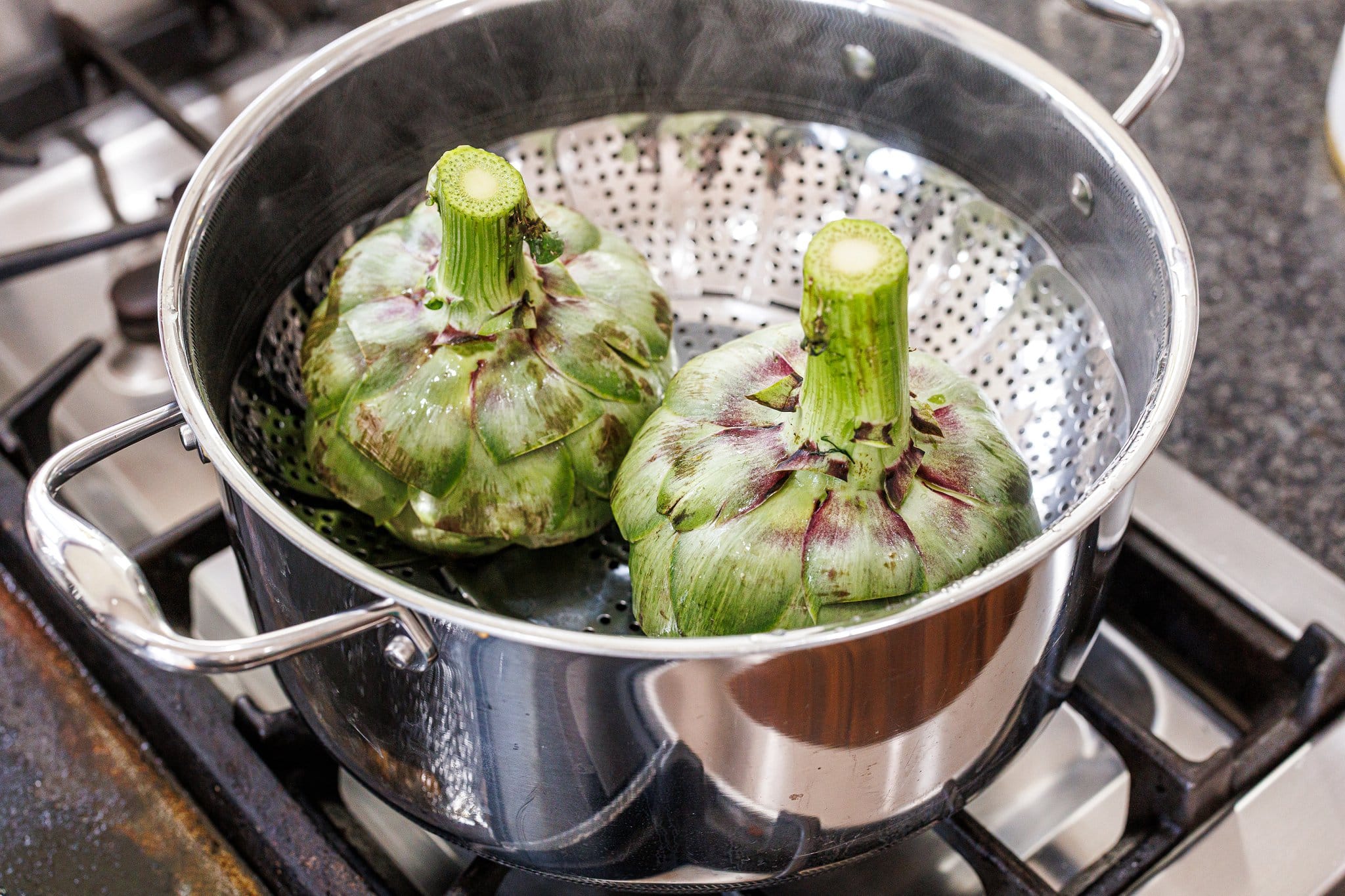 Steaming artichokes on the stove.