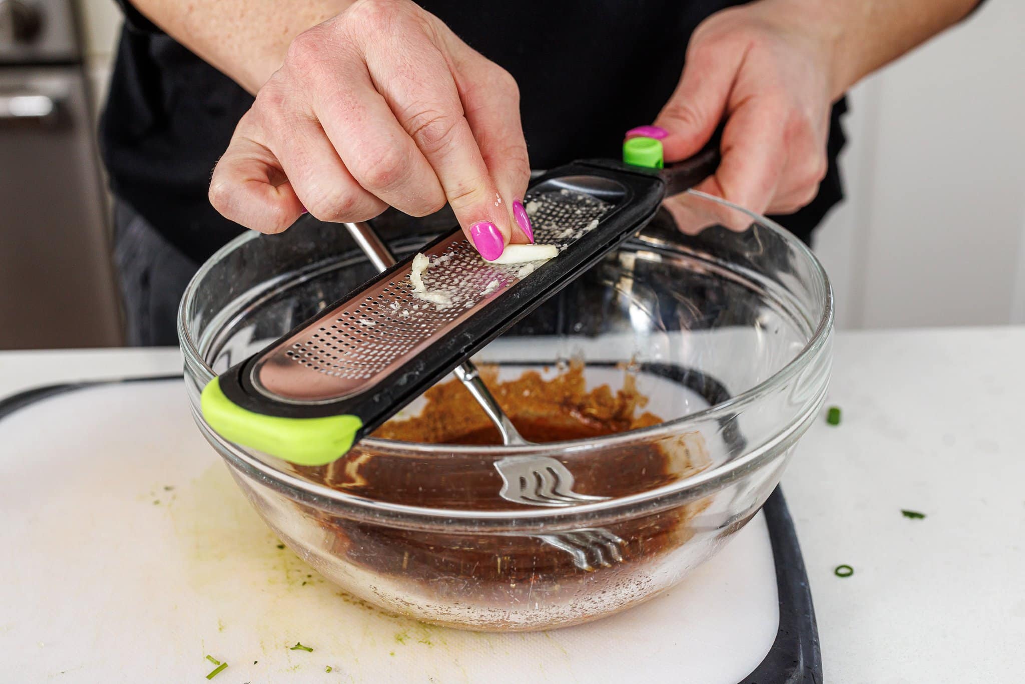 Grating garlic into marinade.