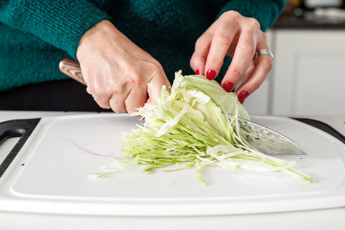 Liz shredding cabbage with a sharp knife.