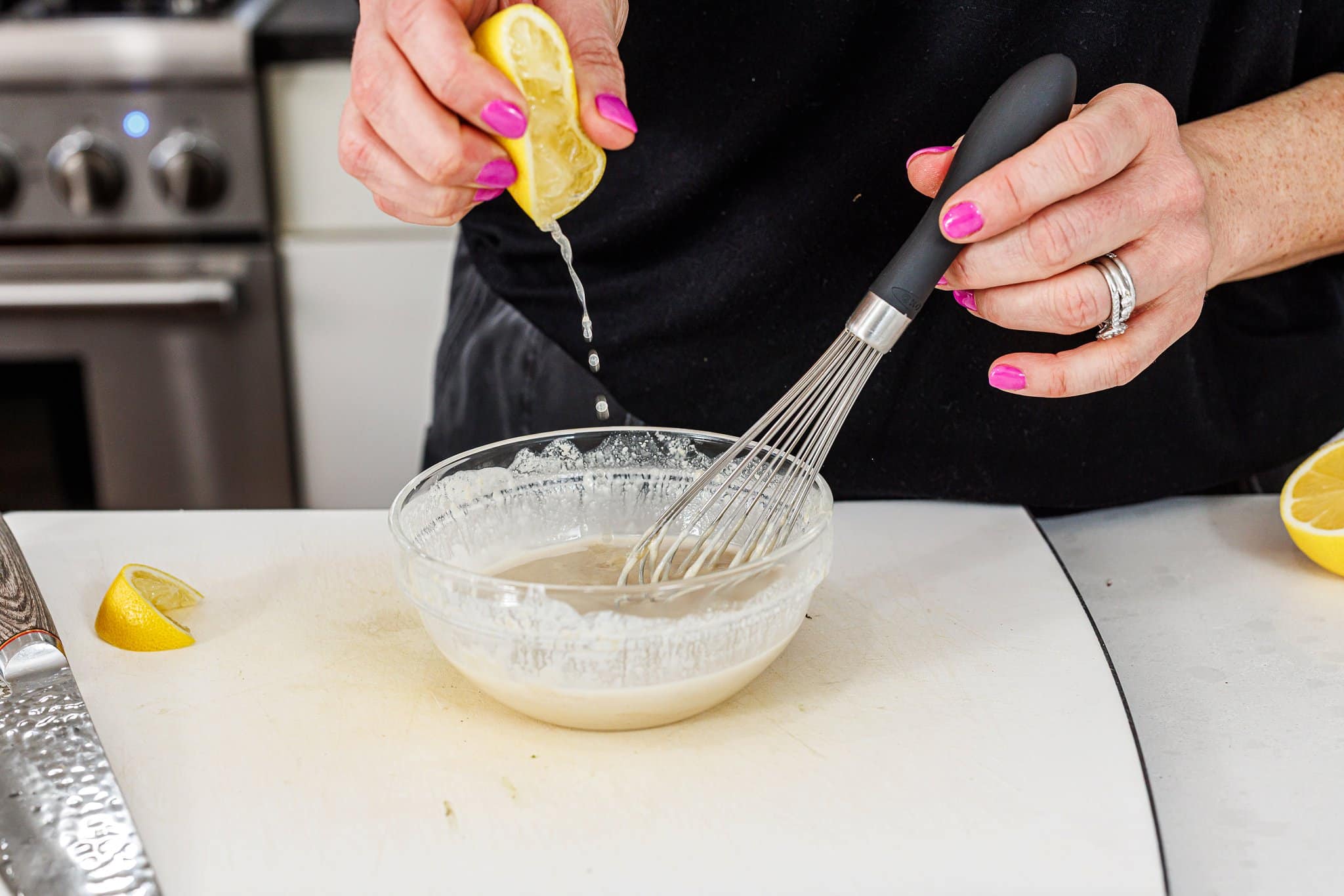 Squeezing fresh lemon juice into sauce.