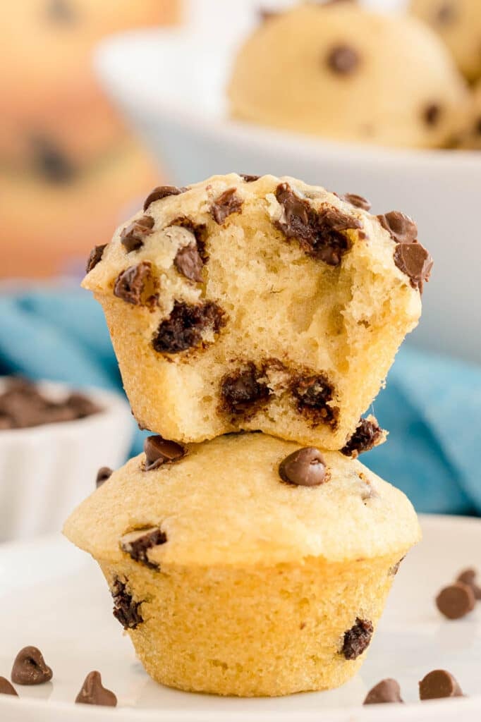 Two mini chocolate chip muffins stacked on a plate, both filled with mini chocolate chips.