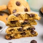 Four stacked halves of chocolate chip cookies with melted chocolate chips visible inside.