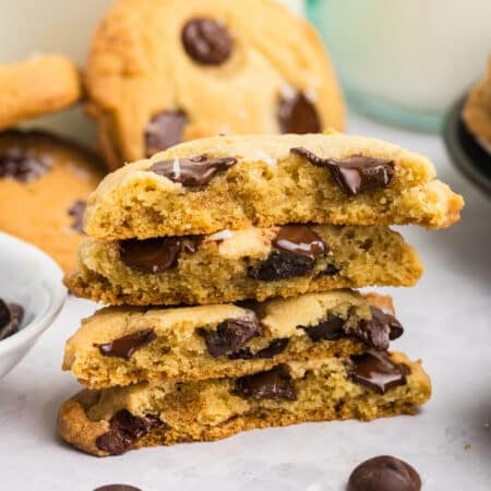 Four stacked halves of chocolate chip cookies with melted chocolate chips visible inside.