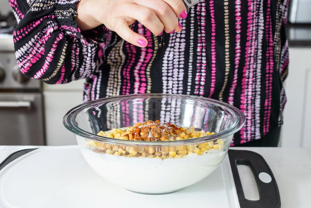 Liz adding pepper to lasagna filling.